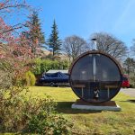 Barrel garden sauna 280 with full glass back wall installed outdoors