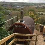 Barrel garden sauna 280 installed outdoors with countryside view
