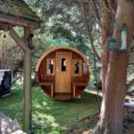 Front view of wooden barrel garden sauna 330 with balcony installed in garden