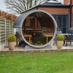 Barrel garden sauna 330 with balcony and full glass front installed outdoors