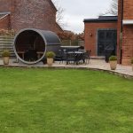 Barrel garden sauna 330 with balcony installed in landscaped garden