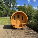 Front view of wooden barrel garden sauna on outdoor decking