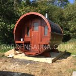 Front view of wooden barrel garden sauna installed outdoors
