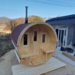 Barrel garden sauna installed outdoors with wood-fired heater