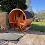 Wooden barrel garden sauna with front porch installed in garden