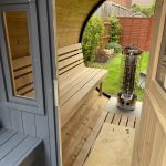 Barrel sauna 280 porch interior with benches and wood heater