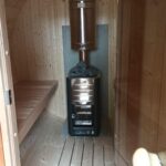Wood-fired sauna heater inside barrel sauna 330 with balcony