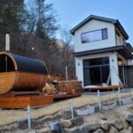 Barrel garden sauna and wooden hot tub installed in modern garden