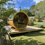 Barrel garden sauna with full glass back wall installed outdoors