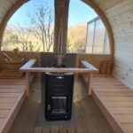 Barrel sauna interior with half-moon glass back wall and benches